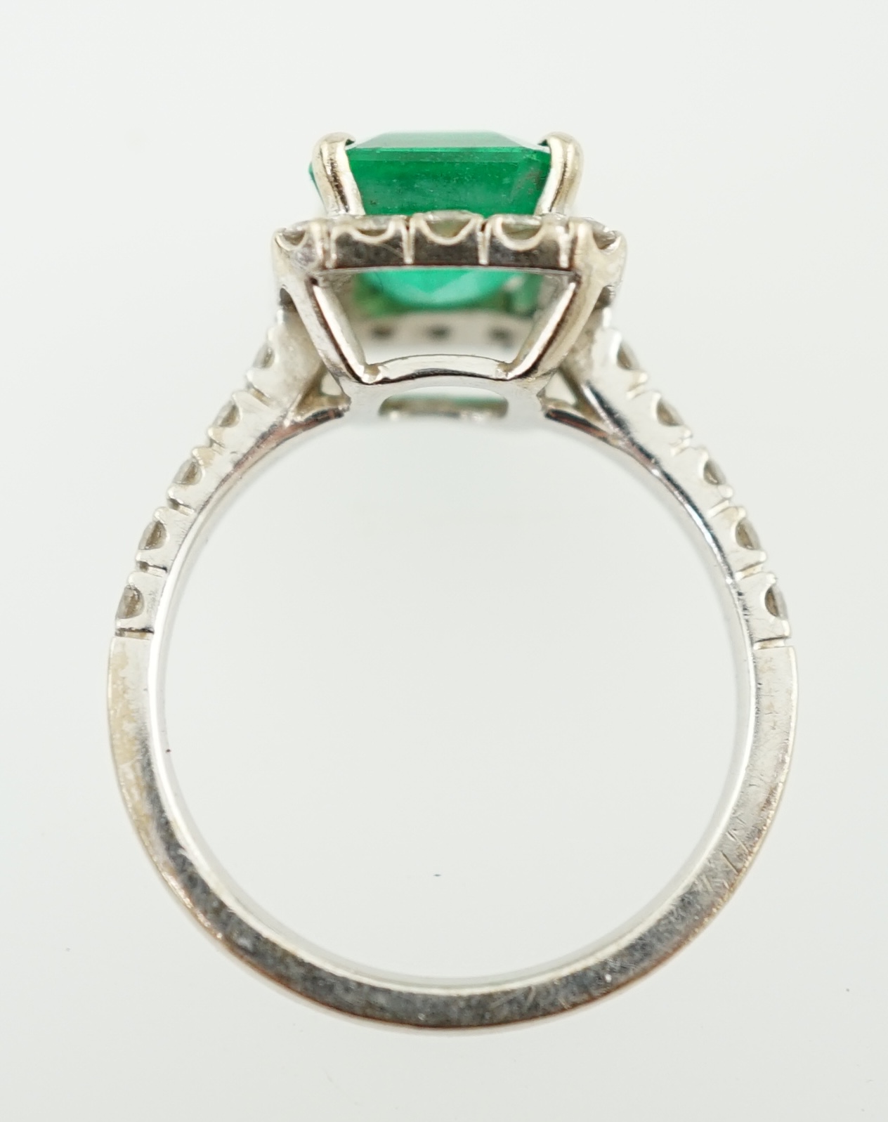 A modern 18k white gold, emerald and diamond set square cluster ring